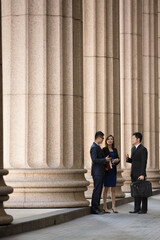 Asian business colleagues outside a Colonial building.