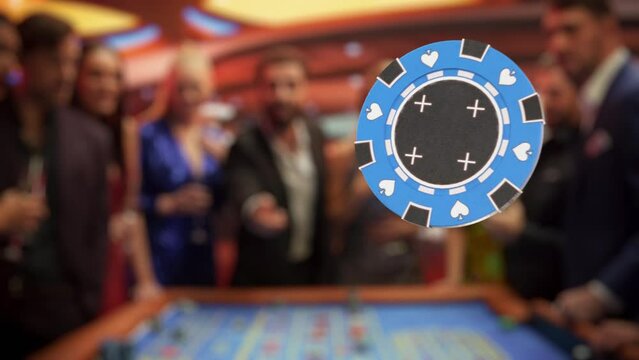 Casino Players Making Bets at a Roulette Table. Vibrant Crowd of International People Enjoying Nightlife in a City. Male Gambler Tossing a Casino Chip with a Template Placeholder Flying in Slow Motion