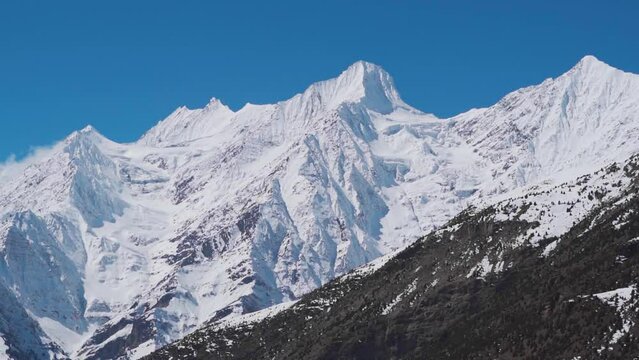 Landscape shot of snow covered Himalayan mountain peaks during the winter season as seen from Keylong at Lahaul Valley in Himachal Pradesh, India. Snowy mountain peaks during the winter season.