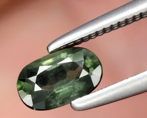 natural dark green sapphire gem on the background