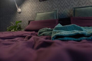 Cluttered bedroom with piles of clothes. An unmade bed in the early morning. selective focus