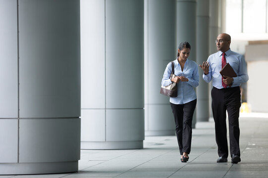 Happy Indian Business colleagues walking outside office.