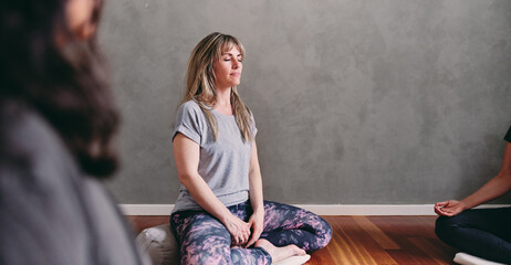 Woman meditating in a restorative yoga class