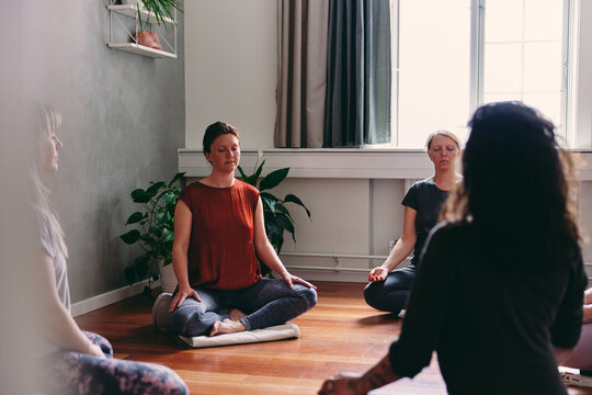 Group of women meditating in a yoga class with their eyes closed