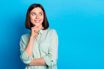 Photo of clever positive woman with bob hairstyle dressed teal shirt look at proposition empty space isolated on blue color background