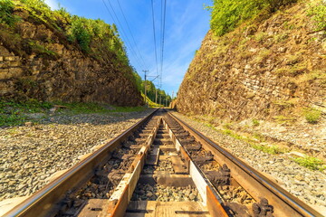 railway going through a stone gorge in the Southern Urals on a summer sunny day