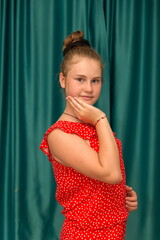 blonde teenage girl in a red suit posing in her room