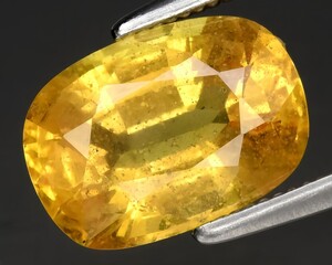 natural yellow sapphire gem on the background