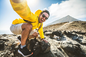 Happy hiker having fun hiking mountains - Active young man taking selfie pic with smart mobile phone device outdoors - Action cam, extreme sports and summertime holidays concept - 747109540