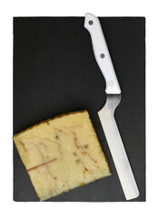 Sheep cheese with chestnuts and a special knife on the service board from the shale, top view