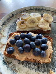 Bluberries and Banana with peanut butter on bread for protein breakfast