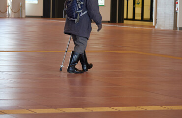 冬の旭川駅の中で歩く一人のシニア男性の姿