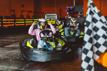 Go kart racer all prepared for the start, woman with starting flag, race on the circuit with...