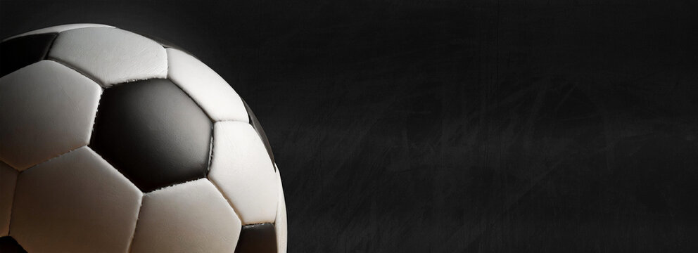 Closeup of an old leather soccer ball isolated on black background with copy space. Generative Ai.