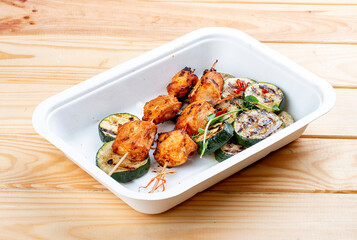 Grilled chicken kebab with zucchini. Healthy diet. Takeaway food.  On a wooden background.