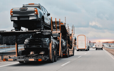 Car carrier trailer truck with brand new off-road vehicles for sale. New car delivery. Car...
