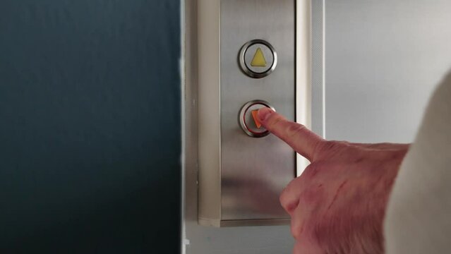 Closeup of woman pushing elevator button, waiting for lift
