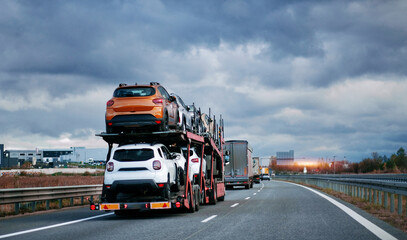 Car carrier trailer truck with brand new off-road vehicles for sale. New car delivery. Car...
