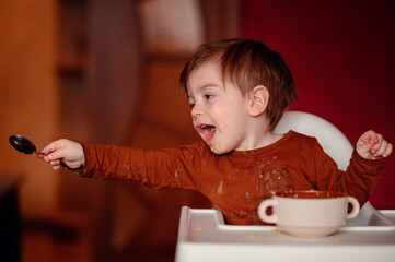 The excitement of a toddler at mealtime is palpable as he extends a spoonful of food, face alight...