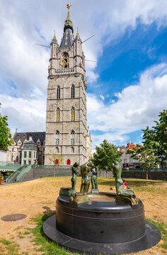 Fountain of kneeling youths with Belfort tower at background, Gent, Belgium