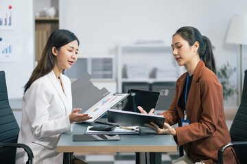 Fototapeta premium Business, technology and office concept - two businessmen with laptop, tablet pc computer and papers having discussion in modern office.