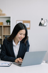 Business women hand working with tablet and laptop computer with documents on office desk in modern office.