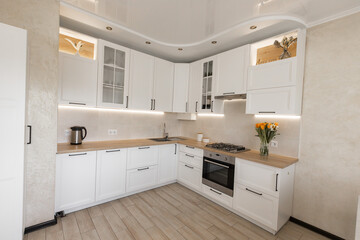 a modern white kitchen interior with wooden worktop