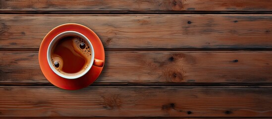 This birds eye view shows a cup of freshly brewed coffee placed on a rustic wooden table. The steaming beverage is set against the natural grains of the wood, creating a simple yet cozy scene.