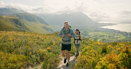 Couple of friends walking, hiking on mountain and travel for fitness, adventure or journey in nature for wellness. Young people trekking with backpack on a path or green hill for cardio and health - obrazy, fototapety, plakaty