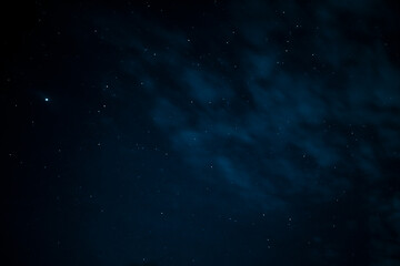 Fototapeta na wymiar Stars in the night sky through the clouds. Beautiful starry night sky with clouds.