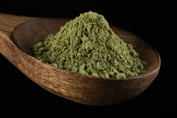 matcha green tea powder sprinkle in wooden spoon