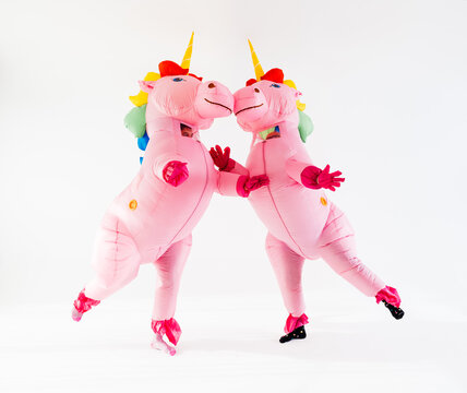 Two inflatable unicorns adorned in gay pride rainbow colors dancing
