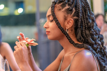 A young woman indulges in the rich flavors of a Italian pizza gourmet, her expression one of serene...