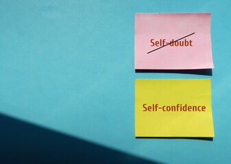 Pink and yellow note with text written SELF DOUBT - SELF CONFIDENCE, concept of to overcome SELF...