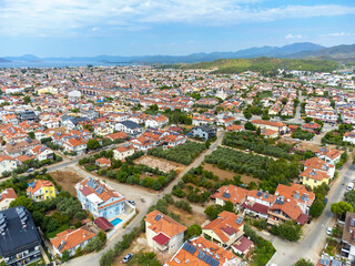 View of city of Fethiye in Turkey, captured by drone on warm summer day. Popular tourist resort on shores of Mediterranean Sea at foot of mountains. Tourist destination with views sea islands