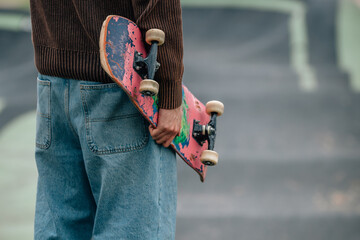 close-up of hands of young man with skateboard on the street