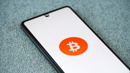 Bitcoin logo on smartphone screen. Virtual cryptocurrency concept 2025.