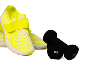 Fashion sneakers on background. Sport shoes in neon green color. black dumbell with sneakers on the white background