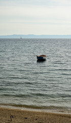 A small fishing boat anchored next to the seashore. Sithonia, Greece, Halkidiki. Paradisos Beach in Neos Marmaras.