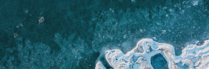 Winter aerial photograph of the icy coast and ice floes in sea water. Top view of the freezing sea....