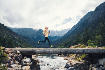 Woman trail runner cross country running in high altitude mountains