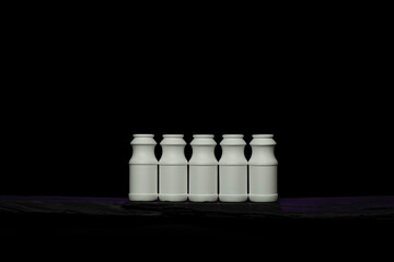Small white plastic bottles with dramatic smoke background
