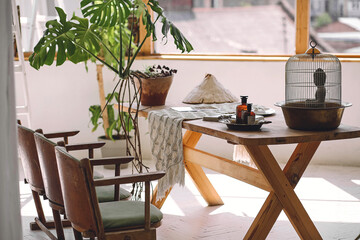 Mock up interior photo of modern living room with wooden floor, table and big windows. Flower pot in the interior