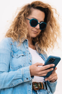 A trendy woman with a post-surgical adapted hand confidently uses a smartphone, highlighting the seamless integration of technology in daily life
