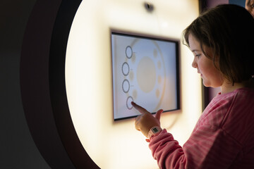 Young girl exploring interactive exhibit at a science museum