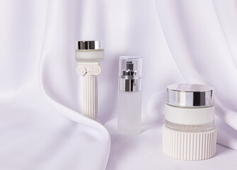 Stylish frosted glass cosmetic jars with silver lid with luxury cream and serum for face and body skin care. Natural care. beauty concept.