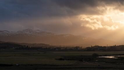 Sunbeams shine across the Kyle of Sutherland with the mountain Carn Salachaidh in the background Sutherland Scotland UK