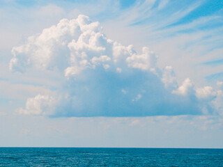 Naklejka na ściany i meble Magical seascape with a big lush cloud above the sea horizon.