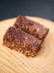 A  beautiful chocolate flapjack dessert slice, served on a rustic wooden plate board. Gourmet and posh trendy cafe and bakery treat. Sugar sweeties.