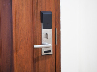 Entrance wooden door with electronic keycard lock system. 